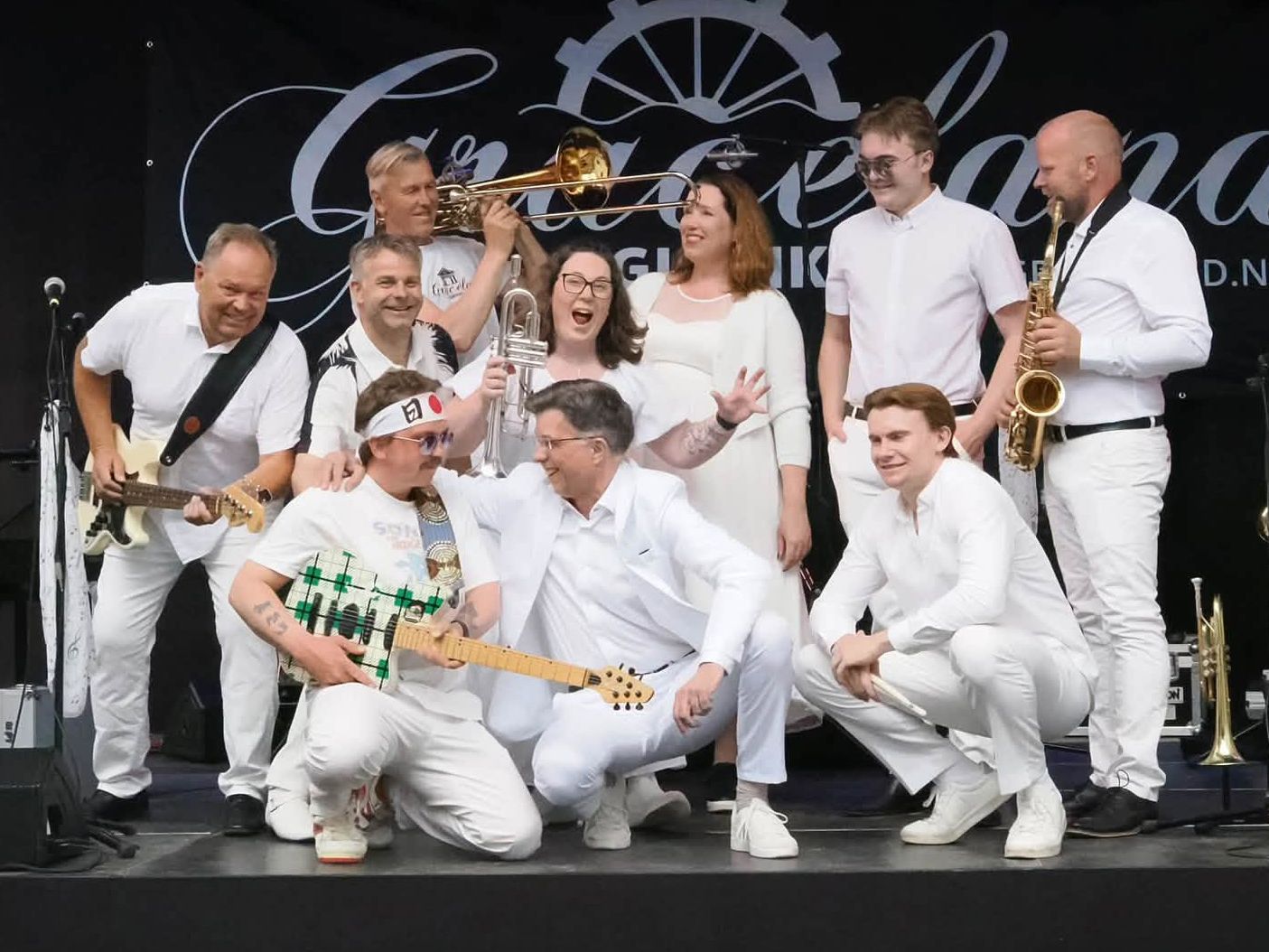 Graceland Gjøvik samlet på scenen med gitarer, trompet, trombone og saksofon